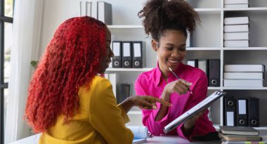 İki Afro-Amerikalı iş kadını çalışma ve planlama ve finans konularında danışmanlık yapıyorlar...