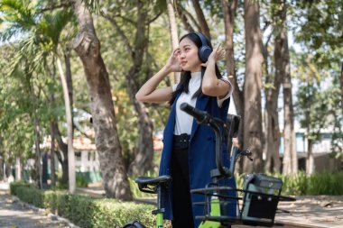 Asyalı iş kadını karbon salınımını azaltmak için şehir dışında çalışmak üzere bisiklet sürüyor. Yeşil enerji için alternatif ulaşım.