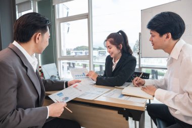 Asyalı iş adamları beyin fırtınası yaptılar ve iş planlarını tartıştılar. Konferans odasındaki şirketin mali veya istatistiksel rakamları.