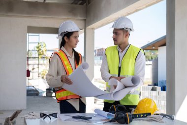 İnşaat mühendisi takımları modern kentteki inşaat sahasında birlikte çalışan işçi kaskı takıyorlar. Foreman Endüstri Mühendislik Mühendisliği ekip çalışması. Asya endüstrisi profesyonel takımı.