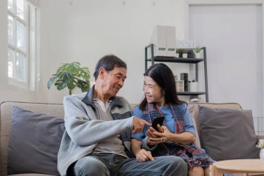 60 'lı yaşlarda yaşlı bir çift boş zamanlarını oturma odasındaki kanepede birlikte eğlenerek geçirir...