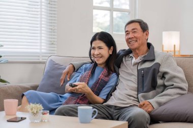 60 'lı yaşlarda yaşlı bir çift boş zamanlarını oturma odasındaki kanepede birlikte eğlenerek geçirir...