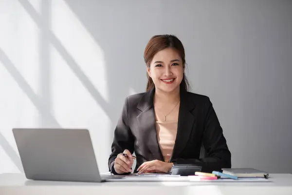 Happy middle-aged businesswoman working in the office. Businesswoman working on laptop and using in remote online job interview meeting on laptop..