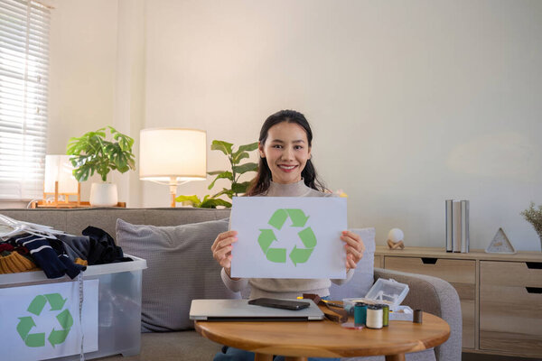 A young woman separates unused clothes and prepares them for donation or recycling in order to reduce air pollution and protect the environment..