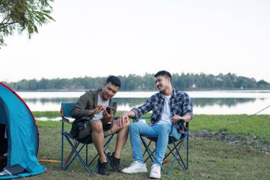 Mutlu Asyalı eşcinsel çift ormanda kamp yapıyor. Romantik meslek gezisi. lgbt kavramı.