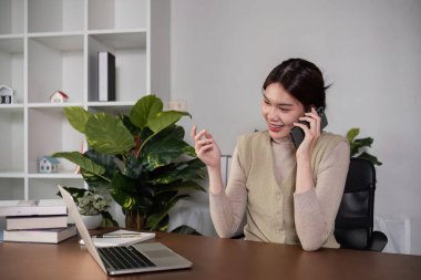 Asyalı iş kadını internette iş toplantısını kontrol ediyor ve yapıyor. Tatillerde evden çalışıyor..