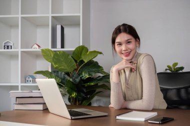 Asyalı üniversite öğrencisi evde oturup bilgisayarlarında bir video programı kullanarak ders çalışıyor...