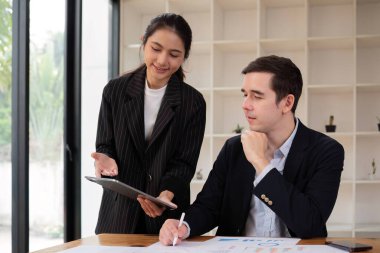 Ofis odasında projeyi tartışan iki işadamı, iş arkadaşlarıyla modern işyerindeki proje planlamasını tartışırken, mali veri raporu hakkında tartışma ve danışmanlık yapıyor...