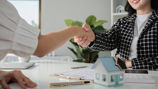 Агент по страхованию недвижимости объединяется для достижения соглашения с бизнес-клиентом о страховании дома или недвижимости..