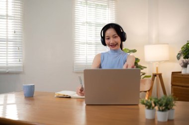 Asyalı üniversite öğrencisi evde oturup bilgisayarlarında bir video programı kullanarak ders çalışıyor...