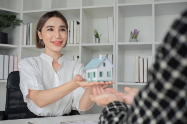 Ev planları ve anahtarları olan bir emlakçı. Anlaşma sağlandıktan ve sözleşme imzalandıktan sonra müşteriye verilir...