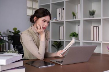 Asyalı kız öğrenci Zoom aracılığıyla iş yönetimi ve muhasebe konularıyla ilgili online video görüşmeleri yapıyor..