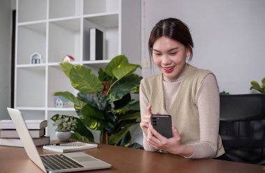 Asyalı üniversite öğrencisi evde oturup bilgisayarlarında bir video programı kullanarak ders çalışıyor...