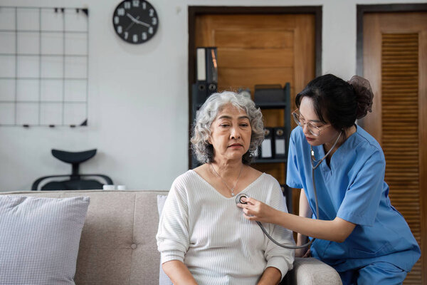 Elderly caregivers are helping to check the health and care for an elderly woman at home..