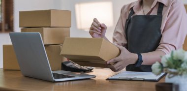 Business From Home Asian woman preparing package delivery box Shipping for shopping online. young start up small business owner at home online order.