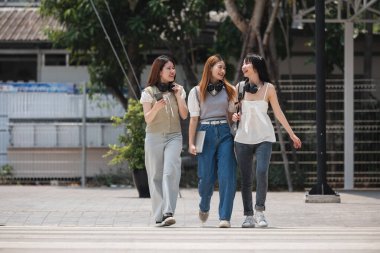 Üniversitede koridorda yürüyen bir grup mutlu öğrenci..