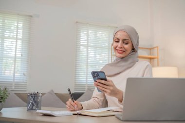 Başörtüsü takan genç Müslüman bir kadın elinde kredi kartıyla internetten alışveriş yapıyordu...