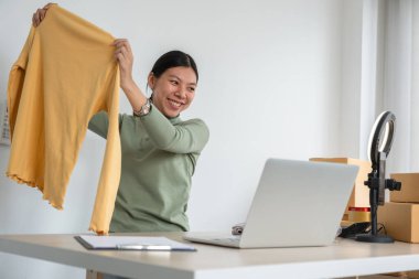 Güzel çevrimiçi satıcı işletmeciler çevrimiçi ürünler satıyorlar. Ürün kutularının olduğu bir odada video yayını yoluyla satılıyor...