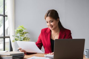 Güzel muhasebeci dizüstü bilgisayarla oturup oturma odasındaki şirketin mali ve vergi rakamlarını hesaplıyor...