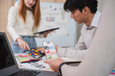 Tasarımcılardan oluşan bir ekip uygulama sisteminin geliştirilmesine yardımcı olur. Yeni programlar geliştirmek için beyin fırtınası fikirleri.