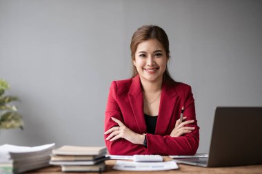 Kendine güvenen Asyalı bir iş kadınının portresi modern bir ofis masasında dizüstü bilgisayar pazarlama konseptini kullanarak çalışıyor..
