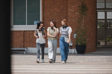 Üniversitede koridorda yürüyen bir grup mutlu öğrenci..