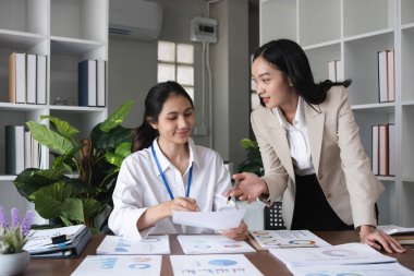 Birbirini destekleyen iş adamlarından oluşan bir ekip. İş danışmanları ve çalışanlar birlikte iş belgeleri üzerinde çalışıyorlar...