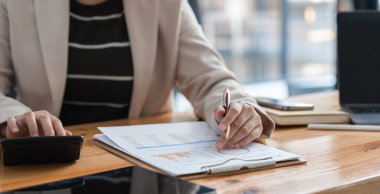 Finansal belgeleri analiz eden ve hesap makinesi, finansal planlama ve doğruluk kavramı kullanan iş kadınlarının yakın plan görüntüleri.