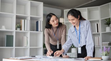 Modern ofis projesinde işbirliği yapan iki iş kadını. Takım çalışması ve profesyonel planlama kavramı.