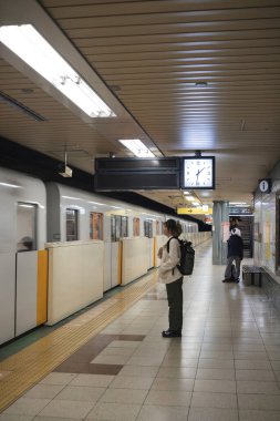 İstasyonda metro treni bekleyen bir kadın. Seyahat ve şehir seyahati kavramı.