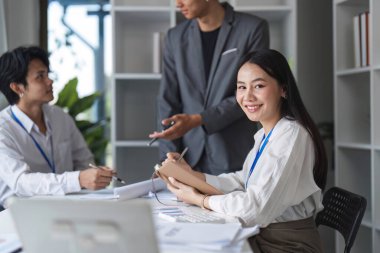 Bir grup iş adamı fikir alışverişinde bulunmak ve çağdaş bir ofis ortamında iş birliği yapmak için bir araya geliyor..