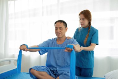 An elderly patient undergoing physical therapy with the assistance of a young female therapist in a modern medical facility. clipart