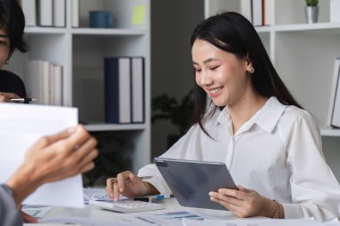 Çeşitli bir iş ekibi, fikir alışverişinde bulunmak, işbirliği ve yenilikleri teşvik etmek amacıyla modern bir ofiste toplanıyor..