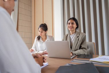 İş dünyasından profesyonellerden oluşan bir ekip, modern bir ofis ortamında ortak bir tartışma, fikir ve stratejileri paylaşıyor..