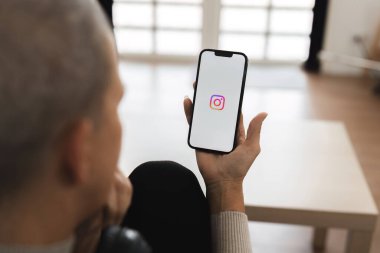 CHIANG MAI, THAILAND - 20 JUL 2024: Bir kadın akıllı telefonlar için Instagram ekranında Instagram uygulamalı Apple iPhone 14 tutuyor