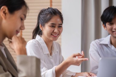 Çeşitli iş adamları canlı bir tartışma içinde, fikirleri paylaşıyor ve modern ofis ortamında işbirliği yapıyorlar..