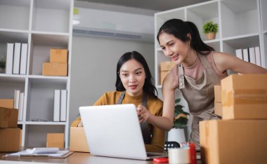 İki lezbiyen aşık evlerinde iş birliği yapıyorlar, ürünlerini internette satıyorlar ve küçük işletmelerini birlikte yönetiyorlar..