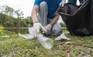 Doğal ortamda çöp toplayan gönüllü bir çift, çevre koruma ve toplum temizliği çalışmalarını destekliyor..