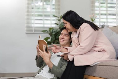 Bir anne ve oğlu bir kanepede birlikte oturup, evde tatil yaparken keyifli bir anı paylaşıyorlar..