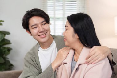 Bir anne ve oğlu sıcak ve sevgi dolu bir anı paylaşarak, sıcak bir oturma odasında rahatlarlar..