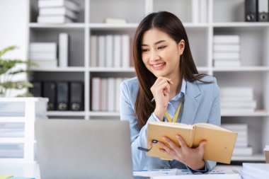 Modern ofis ortamında çalışan bir kadın muhasebeci, finansal yönetim belgeleri üzerinde çalışıyor, profesyonellik ve adanmışlık sergiliyor..