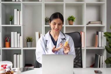 Modern ofis ortamında dizüstü bilgisayar kullanan bir kadın doktor çevrimiçi tıbbi tavsiyelerde bulunur..