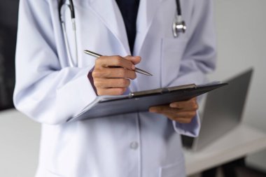 Klinikteki kendine güvenen kadın doktor, elinde bir dosya, profesyonel bakımda hastalara yardım etmeye hazır..