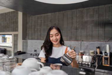 Genç bir barista modaya uygun bir kafede ustalıkla kahve hazırlar. Uzmanlık ve tutku gösterisi yapar..