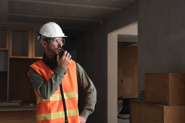 İnşaat alanında radyo kullanan genç bir mühendis modern bina gelişimini sergiliyor..
