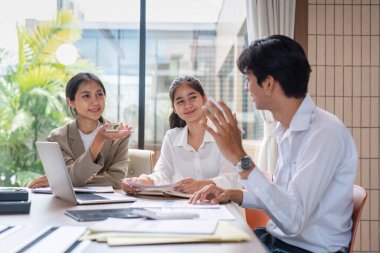 Çağdaş bir ofis ortamında yapılan toplantıda iş planları ve stratejileri tartışan bir iş adamları ekibi.