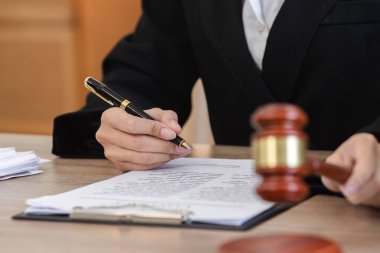 Kadın bir avukat davayla ilgili sözleşmeleri titizlikle inceleyerek profesyonel hukuki süreci vurguluyor..