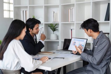 İş dünyasından profesyonellerden oluşan bir ekip, fikir alışverişinde bulunmak ve çalışma stratejilerini tartışmak, işbirliği ve yeniliği teşvik etmek üzere modern bir ofiste toplandı..