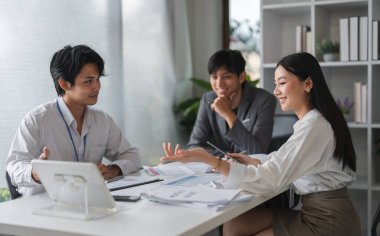 Asyalı iş adamları ve iş kadınlarından oluşan bir ekip, yenilikçi fikirleri tartışmak ve değiş tokuş etmek, işbirliği ve takım çalışmasını teşvik etmek amacıyla modern bir ofiste bir araya geldiler..