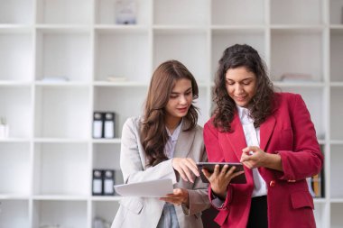 İş kadınları, modern bir ofis ortamında takım çalışması ve işbirliğini teşvik etmek amacıyla meslektaşlarıyla tartışma ve istişarede bulunurlar..